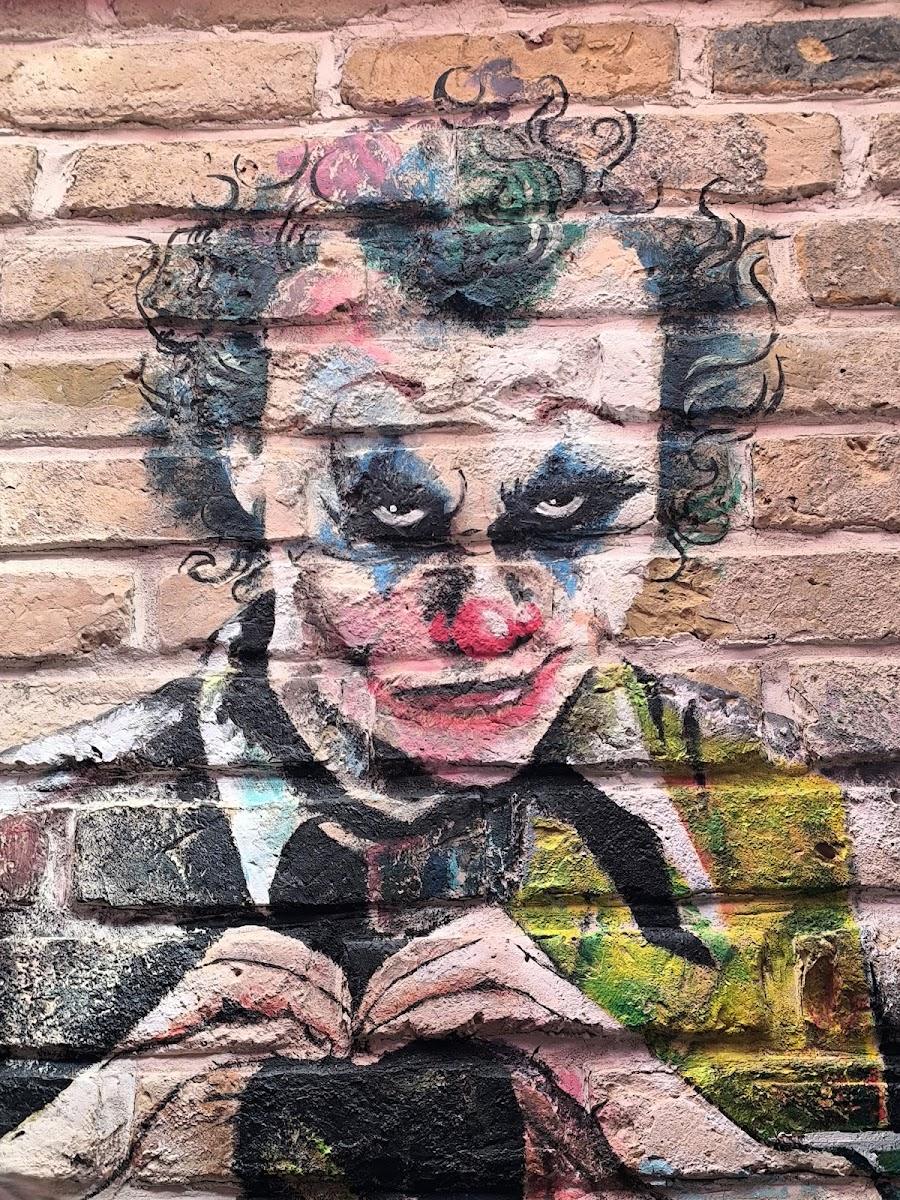 Jokerio piešinys ant plytų sienos